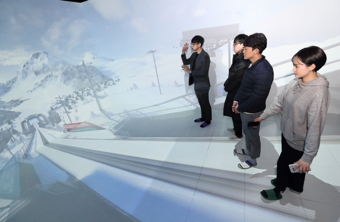 KT 직원이 강릉 올림픽파크에 있는 5G 홍보관의 '텔레포트'에서 입체영상으로 스키점프대에 서 있는 듯한 체험을 하고 있다. [사진=KT]