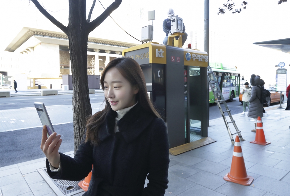 서울 광화문에 교체 설치된 측정소 앞에서 KT 홍보모델이 에어맵코리아를 홍보하고 있다.  [사진=KT]