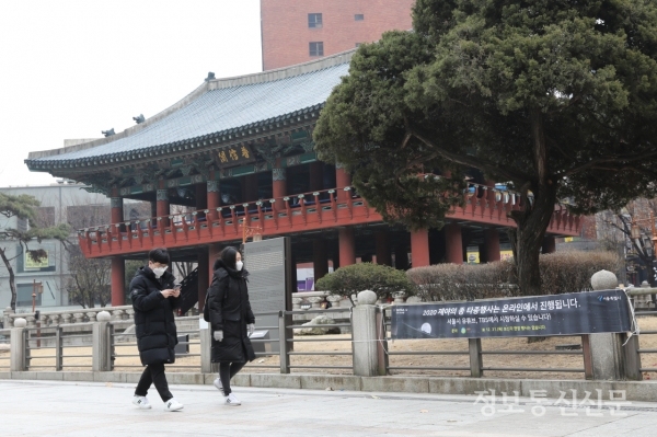코로나19 확산 방지를 위해 서울 보신각 '제야의 종 타종행사'가 현장행사 없이 온라인으로 진행된다. 안내 현수막을 바라보는 시민.