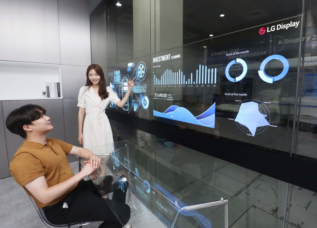 10일 서울 코엑스에서 열린 K-디스플레이 2022에서 LGD 모델이 회의실용 투명 OLED 솔루션을 사용하고 있다. [사진=LG디스플레이]