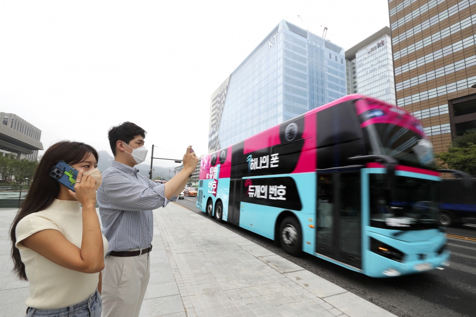 사진은 KT 고객이 ‘듀얼번호 버스’를 촬영해 SNS 올리는 인증샷 이벤트에 참여하는 모습