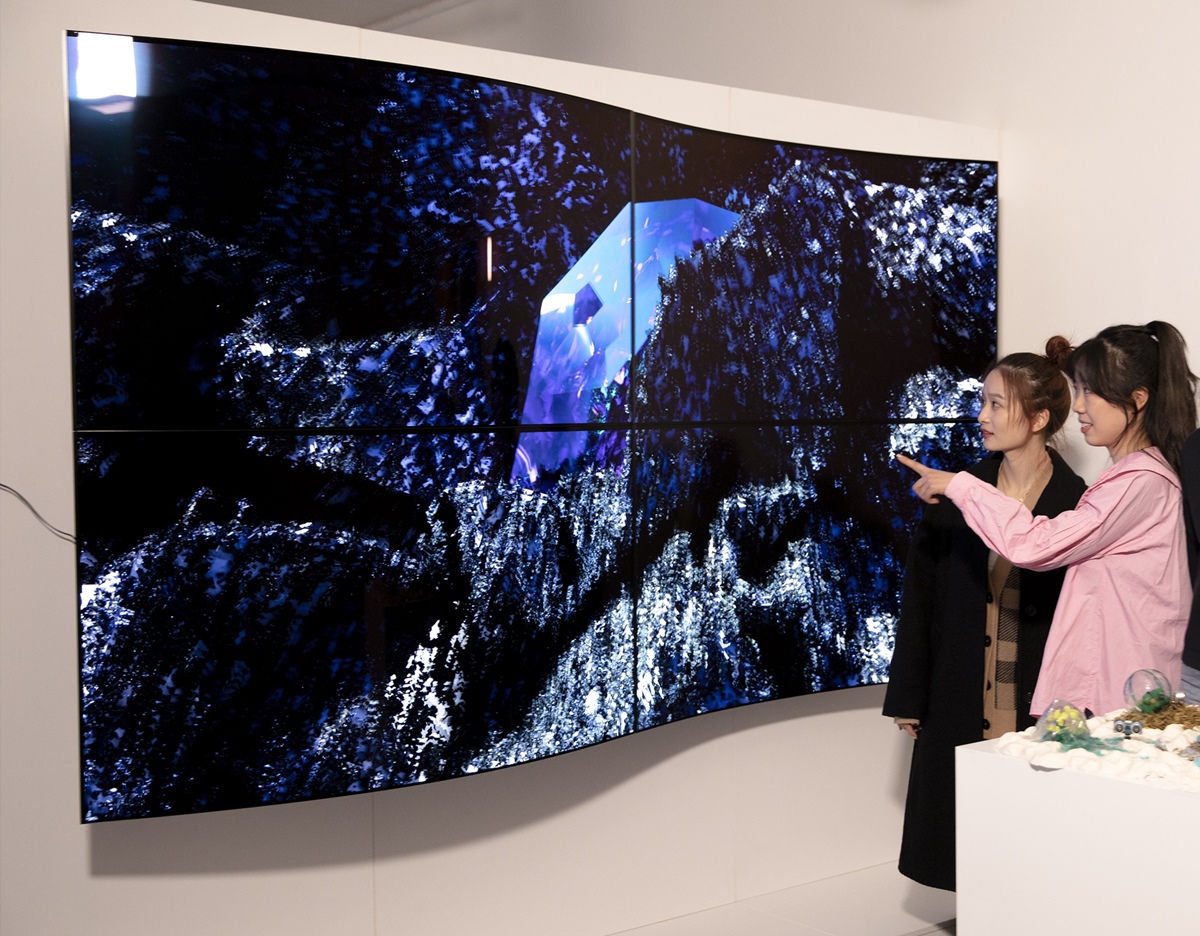 관람객들이 LG디스플레이의 55인치 커브드 OLED 패널 4대를 상하좌우로 이어붙여 만든 작품 ‘보이지 않는 혁신’을 감상하고 있다. [사진=LG디스플레이]