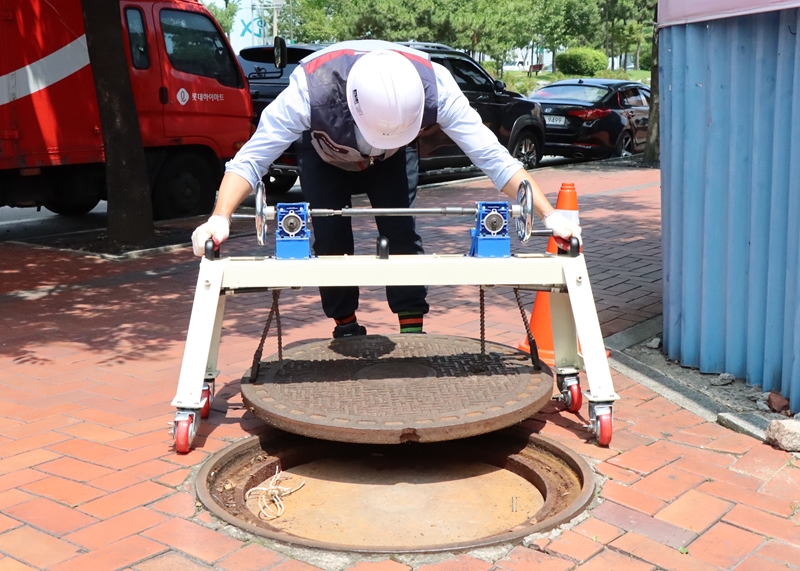 ‘체인기어식 맨홀 개폐기’를 이용하면 1명의 작업자가 맨홀 뚜껑을 여닫을 수 있다.
